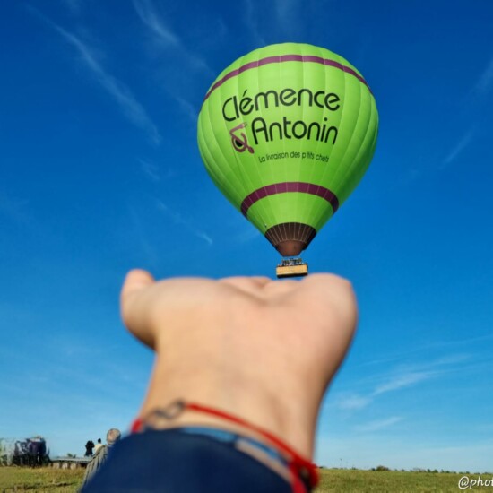 Illusion d'optique d'une montgolfière dans la paume d'une main
