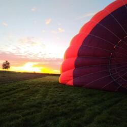 Photo dans une plaine au lever du jour pendant le gonflage d'une montgolfière
