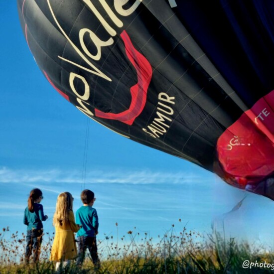 Trois enfants devant le gonflage d'une montgolfière