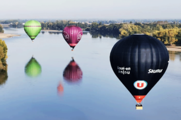 Trois montgolfières en vol au-dessus de l'eau