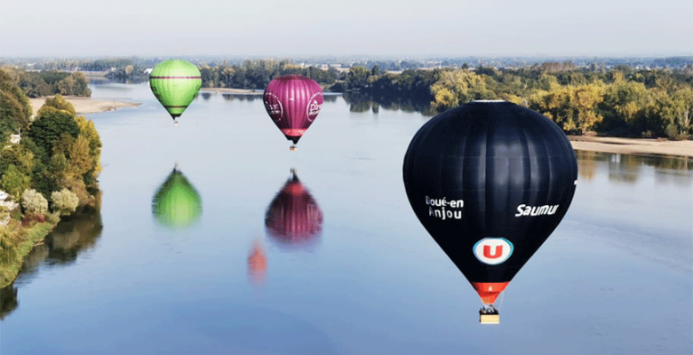 Trois montgolfières en vol au-dessus de l'eau
