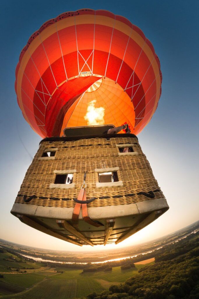 Montgolfière orange et rouge au décollage.