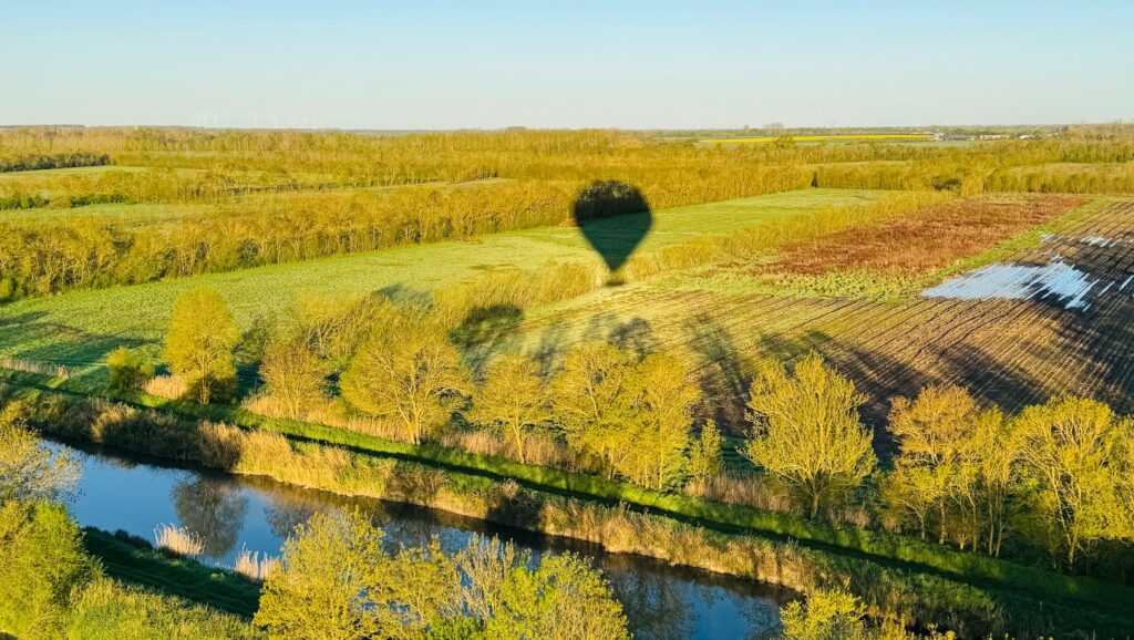ombre d'un montgolfière au dessus de la compagne verdoyante du marais poitevin